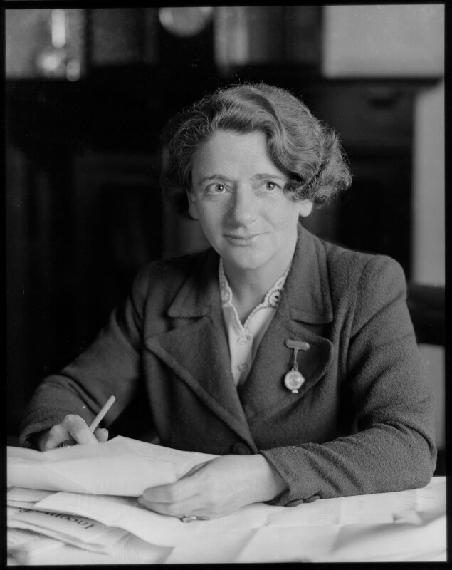 Black and white photo of Ellen Wilkinson working with documents