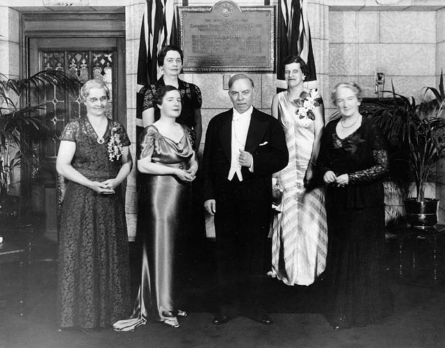 Black and white photo of Unveiling Plaque to Valiant Five with five women and one man in front of the plaque